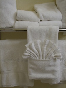 Fresh, fluffy white towels folded into pockets, with wash-cloth fans tucked in.